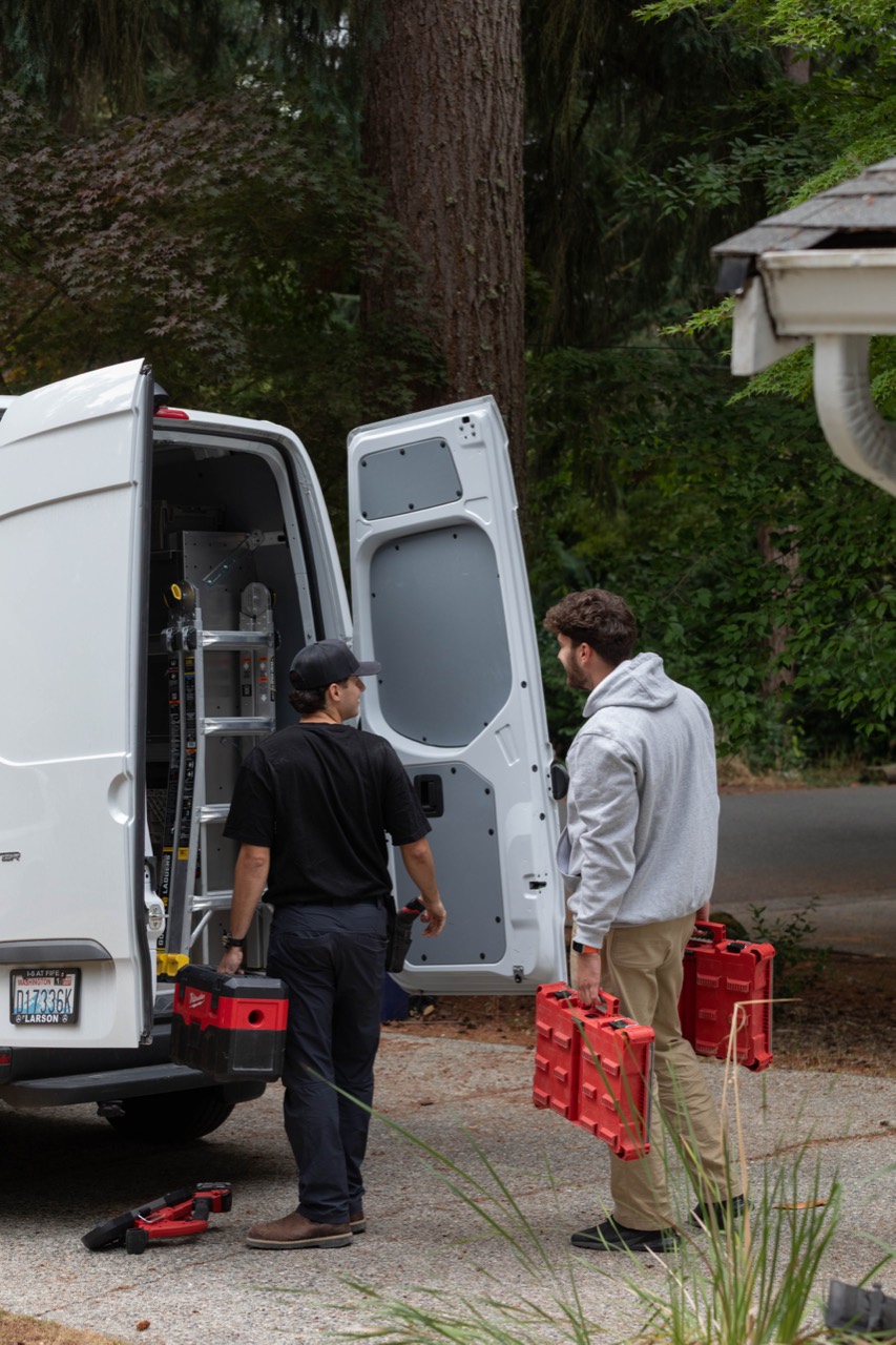 The Wired by Dave crew carrying tools beside their service van